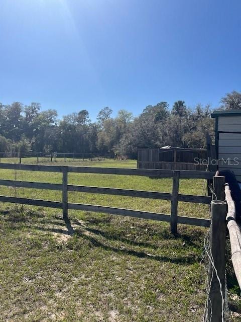 view of gate with fence and a lawn