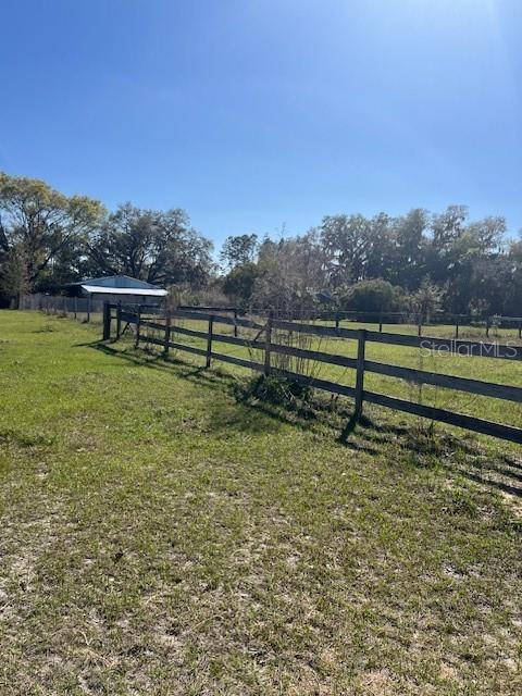 view of yard featuring a rural view and fence