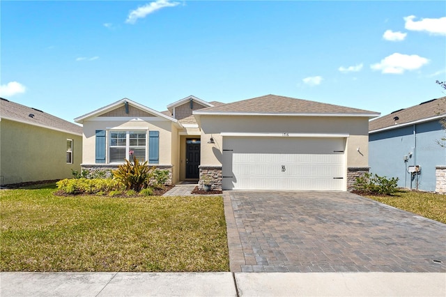 view of front facade featuring an attached garage, stone siding, decorative driveway, stucco siding, and a front yard