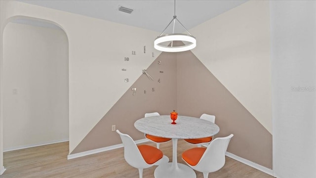 dining area featuring visible vents, baseboards, and wood finished floors