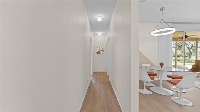 corridor featuring wood finished floors and baseboards