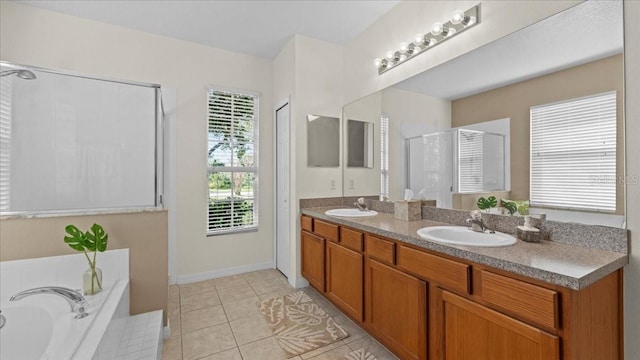 full bath with tile patterned flooring, a garden tub, double vanity, and a sink