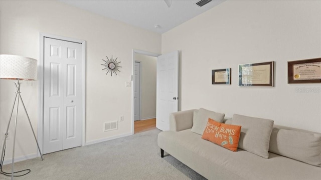 carpeted living area with visible vents and baseboards