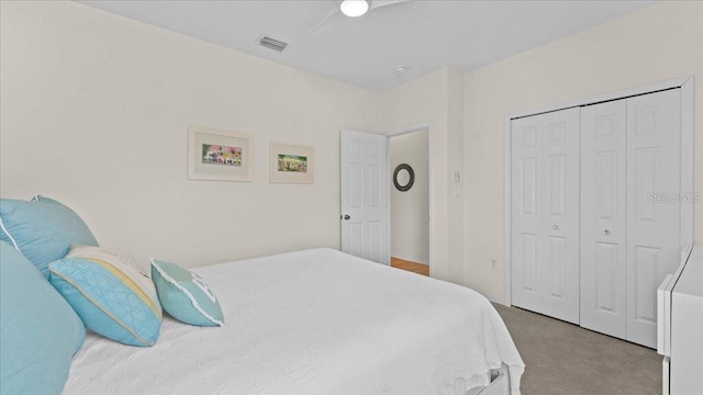 carpeted bedroom featuring visible vents, a closet, and a ceiling fan