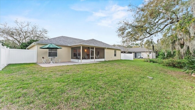 back of house featuring stucco siding, a lawn, a patio, a fenced backyard, and a sunroom