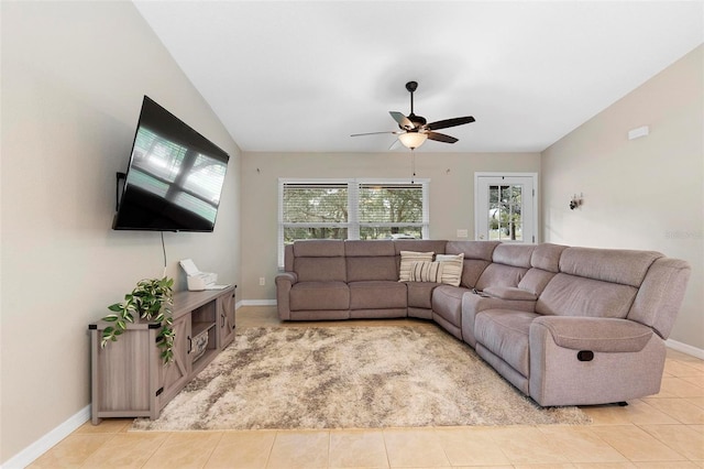 living area with lofted ceiling, light tile patterned flooring, a ceiling fan, and baseboards