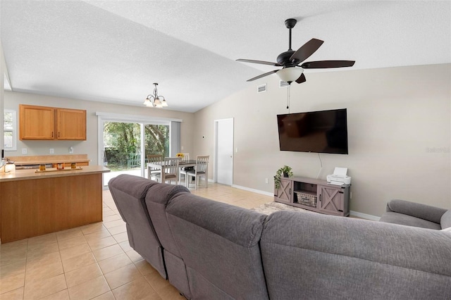 living room featuring light tile patterned floors, vaulted ceiling, a textured ceiling, baseboards, and ceiling fan with notable chandelier