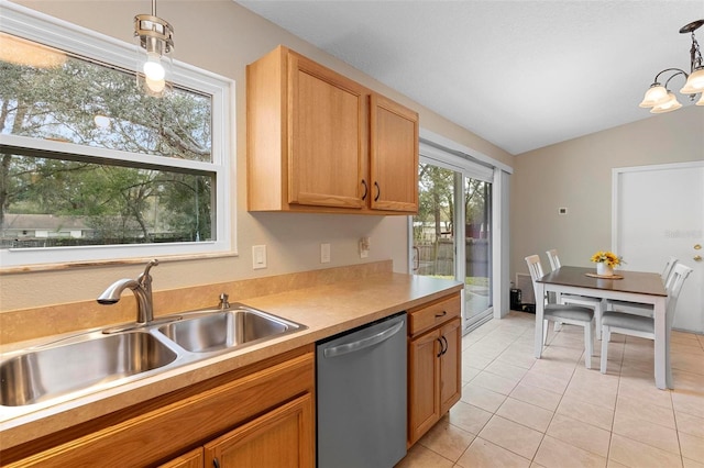 kitchen with lofted ceiling, decorative light fixtures, light countertops, stainless steel dishwasher, and a sink