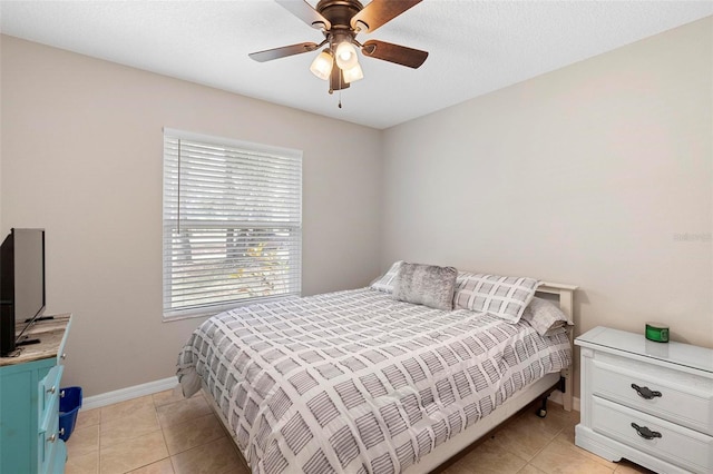 bedroom with light tile patterned floors, ceiling fan, and baseboards