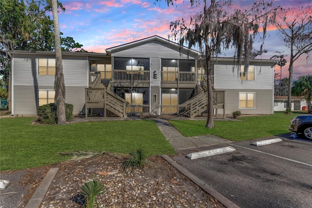 property at dusk featuring stairs and uncovered parking