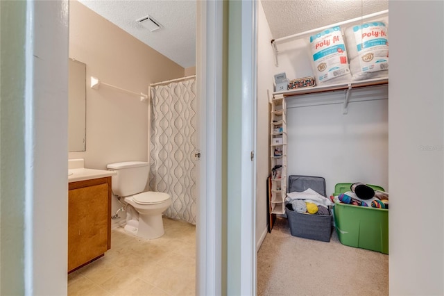 full bath featuring toilet, visible vents, a textured ceiling, and vanity