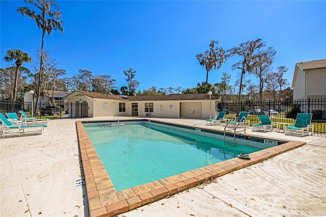 community pool with a patio and fence