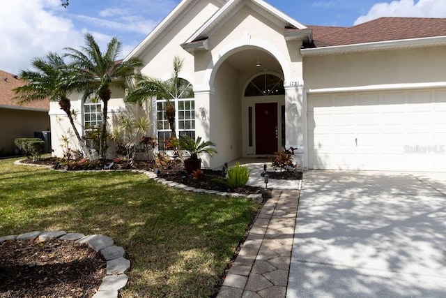 view of front of property featuring an attached garage, a shingled roof, a front yard, and stucco siding