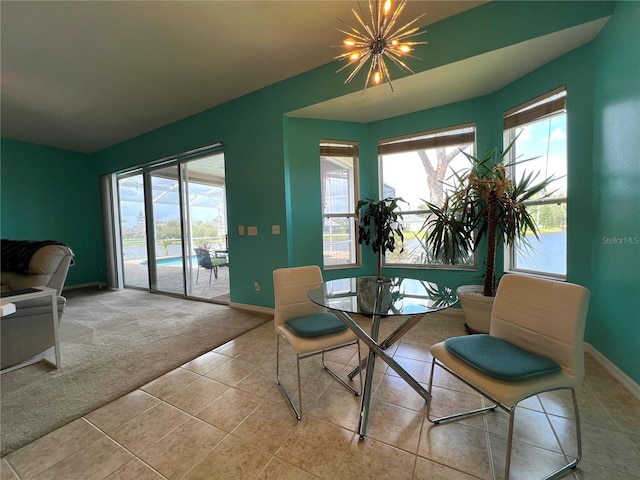 tiled dining room featuring carpet floors, plenty of natural light, baseboards, and an inviting chandelier