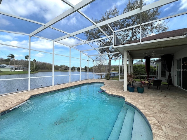 pool with glass enclosure, a patio area, and a water view