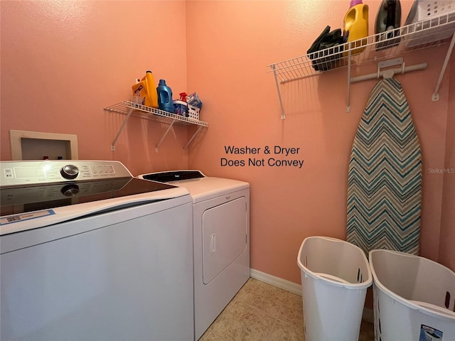 clothes washing area with laundry area, light tile patterned flooring, washer and clothes dryer, and baseboards