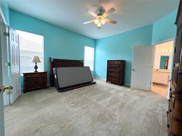 bedroom with lofted ceiling, ceiling fan, a textured ceiling, light colored carpet, and baseboards