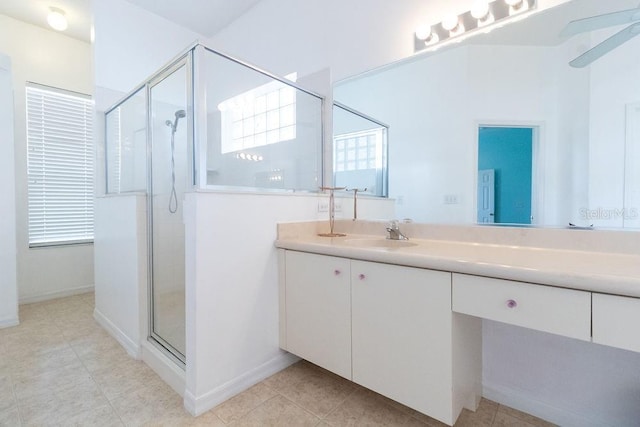 full bathroom featuring a stall shower, vanity, and baseboards