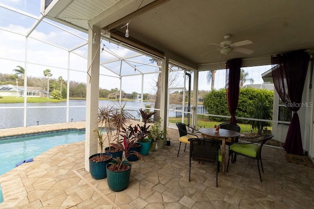 sunroom / solarium with a ceiling fan and a water view