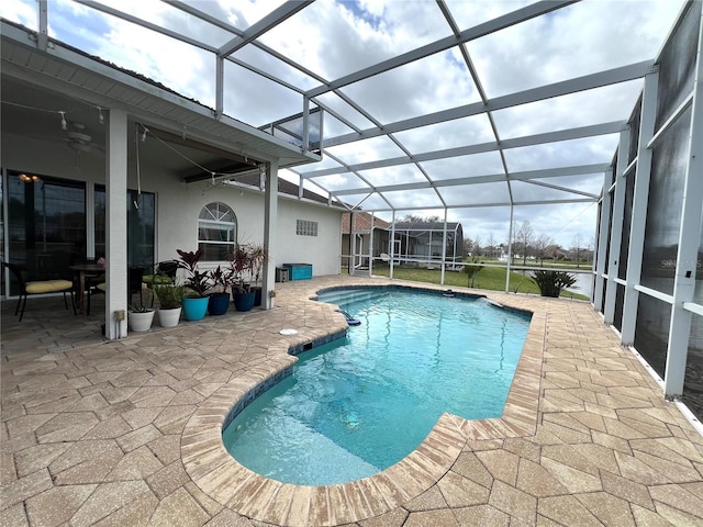 outdoor pool with glass enclosure, ceiling fan, and a patio