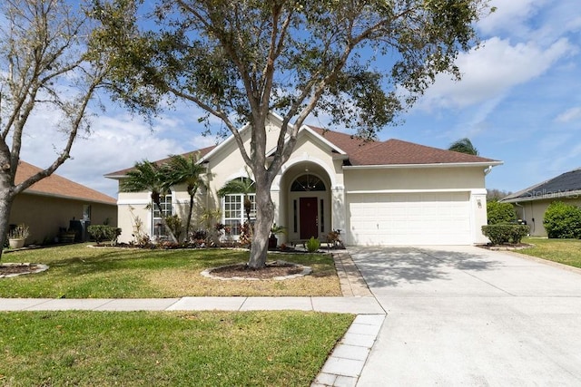 single story home featuring an attached garage, a front lawn, concrete driveway, and stucco siding