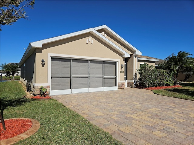 view of front of home featuring a garage, stone siding, a front lawn, and stucco siding