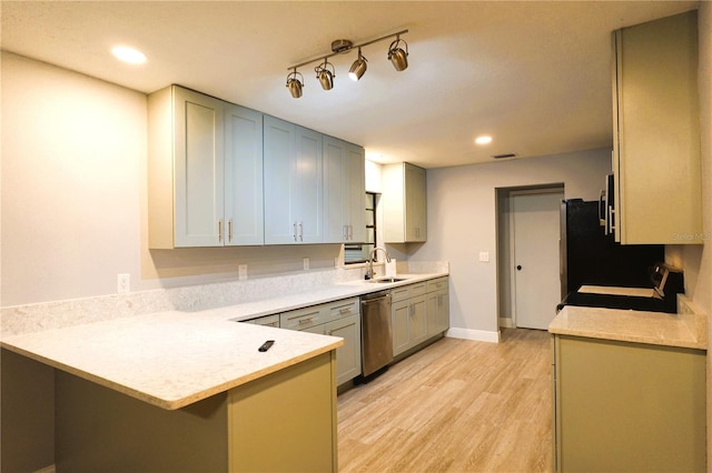 kitchen with light countertops, stove, a sink, dishwasher, and a peninsula