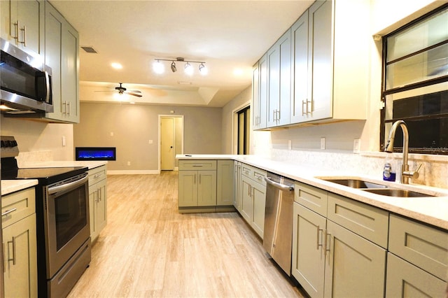 kitchen featuring stainless steel appliances, a sink, visible vents, light countertops, and light wood finished floors