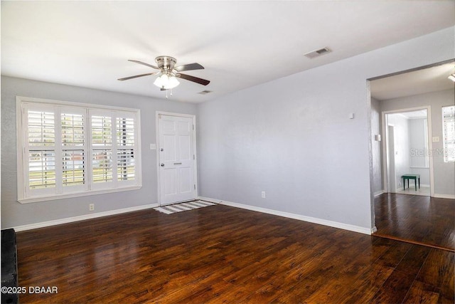 spare room featuring a ceiling fan, baseboards, visible vents, and wood finished floors