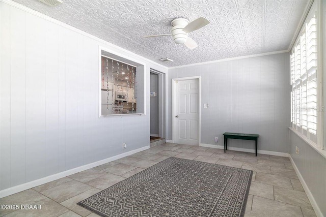 spare room featuring ceiling fan, baseboards, an ornate ceiling, and crown molding