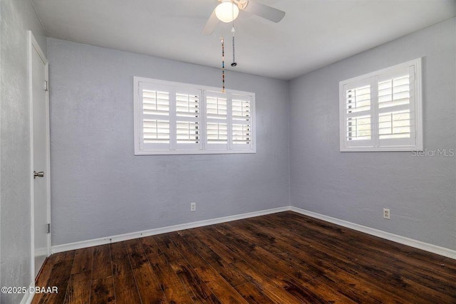 unfurnished room with plenty of natural light, wood finished floors, a ceiling fan, and baseboards