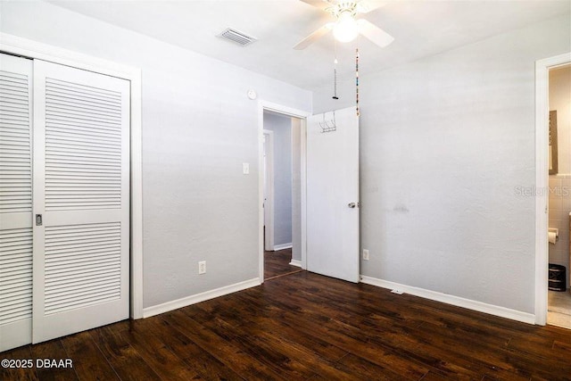 unfurnished bedroom with baseboards, a closet, visible vents, and hardwood / wood-style flooring