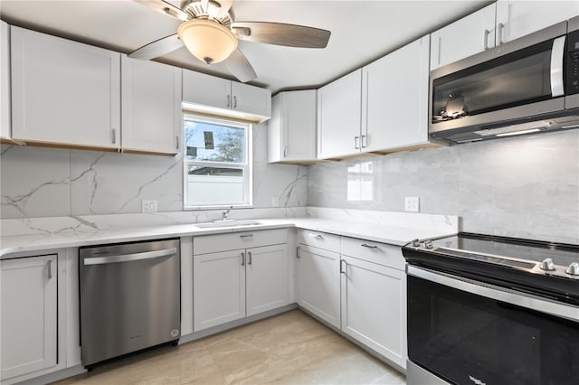 kitchen featuring white cabinetry, decorative backsplash, stainless steel appliances, and a sink