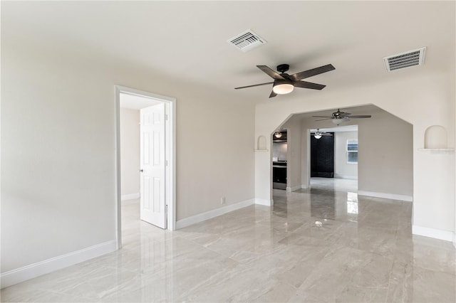 unfurnished room featuring arched walkways, marble finish floor, and visible vents