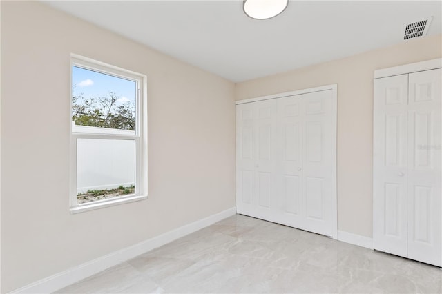 unfurnished bedroom with visible vents and baseboards