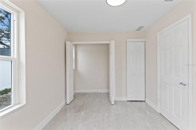 unfurnished bedroom with baseboards, visible vents, and a closet