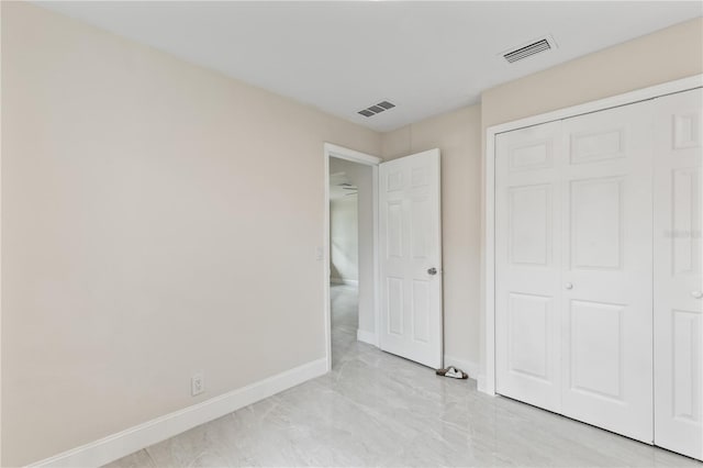 unfurnished bedroom featuring a closet, visible vents, and baseboards