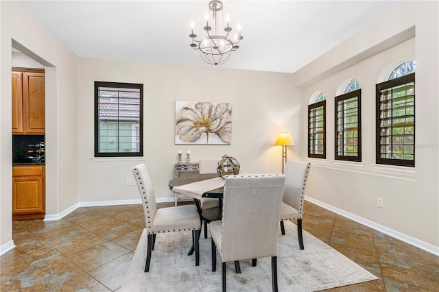 dining room with baseboards and a chandelier