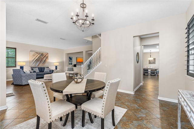 dining space featuring stairs, baseboards, visible vents, and a chandelier