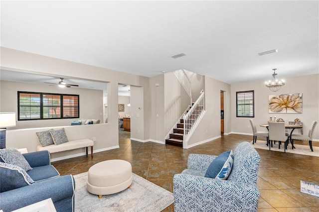 tiled living area with a wealth of natural light, visible vents, baseboards, and stairs