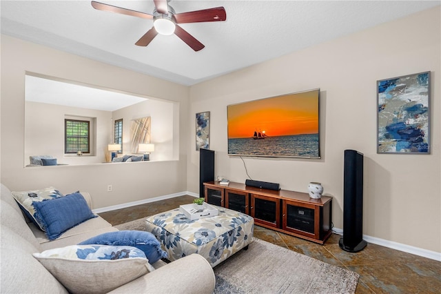 living room with baseboards and a ceiling fan