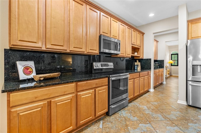 kitchen with decorative backsplash, dark stone countertops, baseboards, and stainless steel appliances