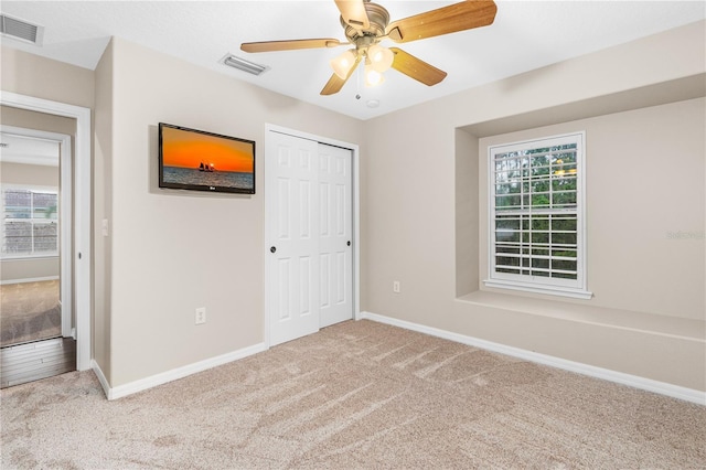 unfurnished bedroom with baseboards, visible vents, and carpet floors