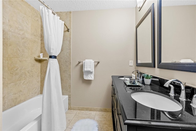 bathroom with tile patterned flooring, shower / bath combo with shower curtain, double vanity, a textured ceiling, and a sink