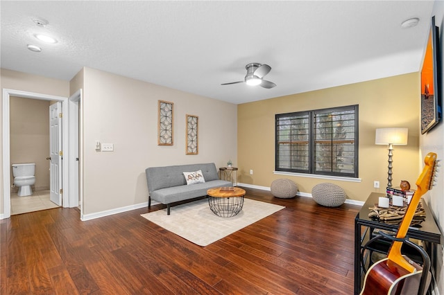 living room with wood finished floors, baseboards, and ceiling fan