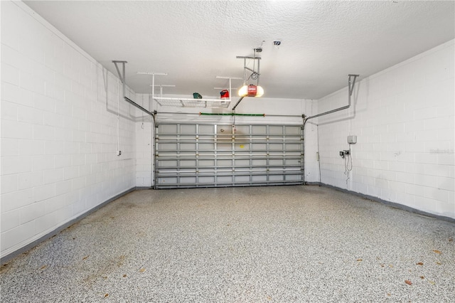 garage featuring concrete block wall and a garage door opener