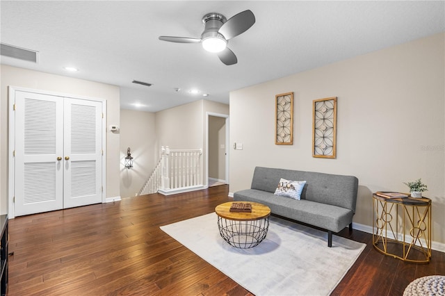 living area with visible vents, wood-type flooring, baseboards, and a ceiling fan