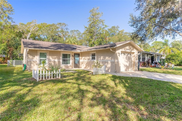 single story home featuring a garage, driveway, a front lawn, and stucco siding