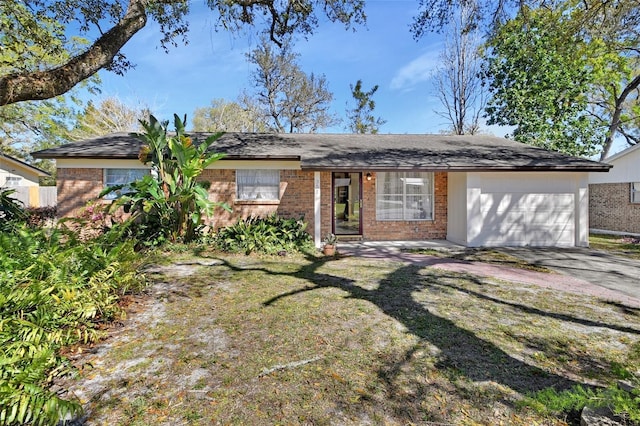 single story home with a garage, driveway, a front yard, and brick siding