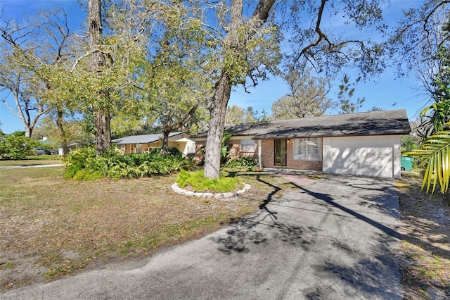 view of front of house featuring brick siding, driveway, and an attached garage